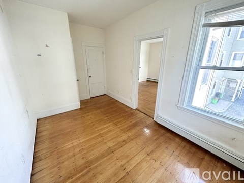 Empty room with wooden floors and white walls.
