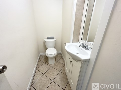 A white toilet sits next to a sink in a small bathroom.