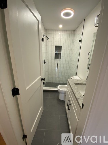 A bathroom with a toilet, sink, and shower.