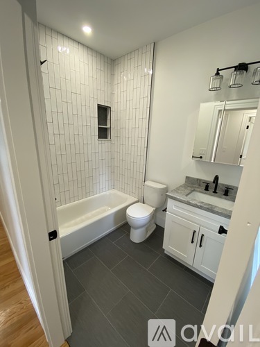 A bathroom with a toilet, sink, and bathtub.