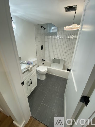 A bathroom with a toilet, sink, and mirror.