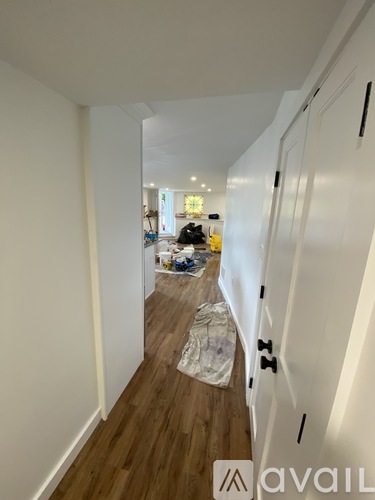 A hallway with a white door on the right and a white wall on the left.