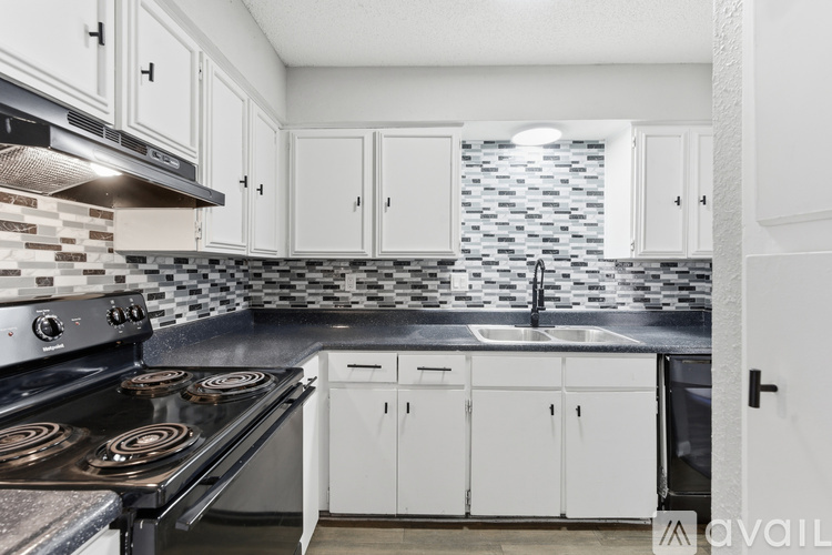 A kitchen with white cabinets and a black stove top.