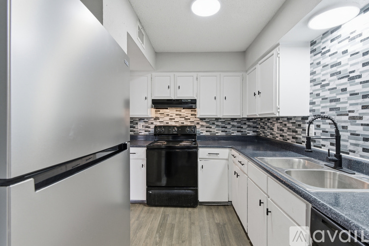 A kitchen with white cabinets and a black oven.