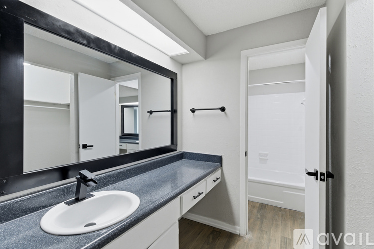 A bathroom with a sink, mirror, and towel rack.