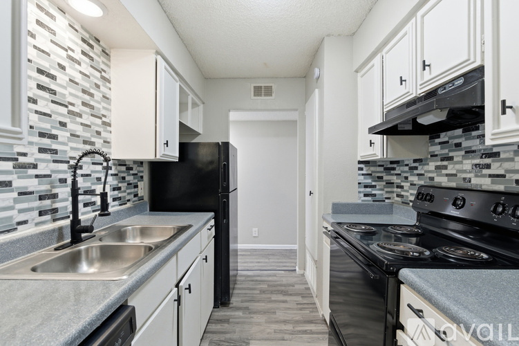 A kitchen with black appliances and white cabinets.