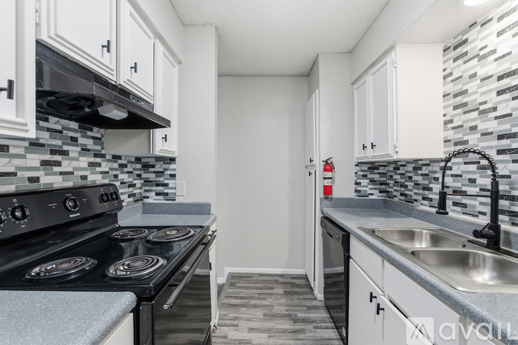 A kitchen with a black stove top oven and white cabinets.