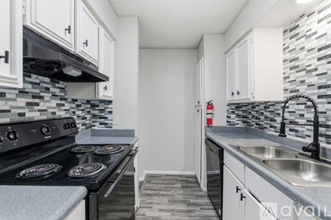 A kitchen with a black stove top oven and white cabinets.