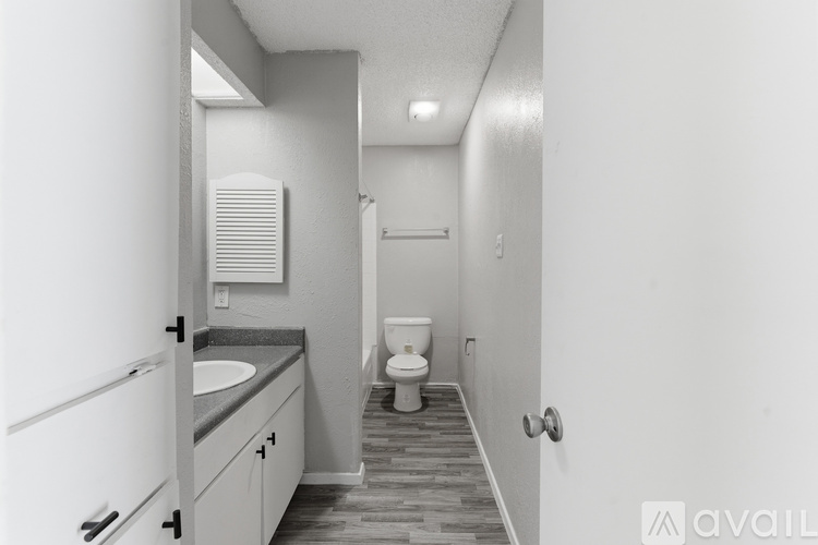 A bathroom with a toilet, sink, and mirror.