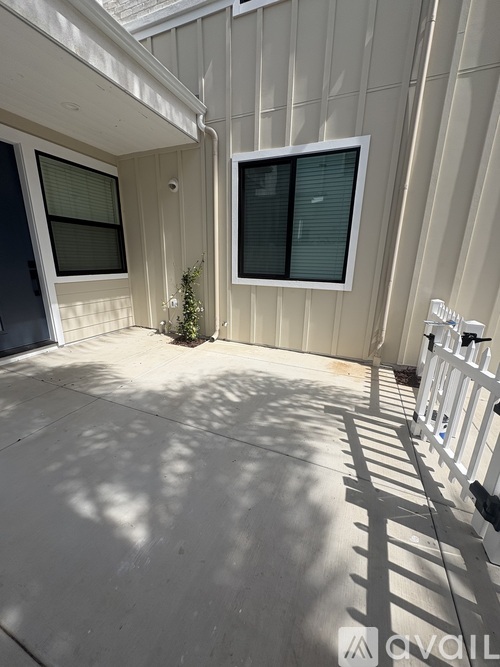 A hallway with a black door and a black mat on the floor.