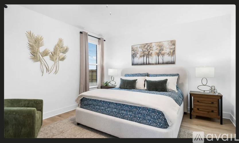 A bedroom with a bed, a chair, and a painting on the wall.