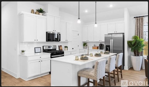 A modern kitchen with white cabinets and a dining table set for four.