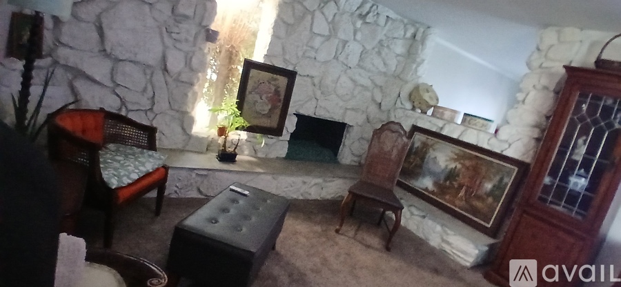 A room with a stone wall and a fireplace.