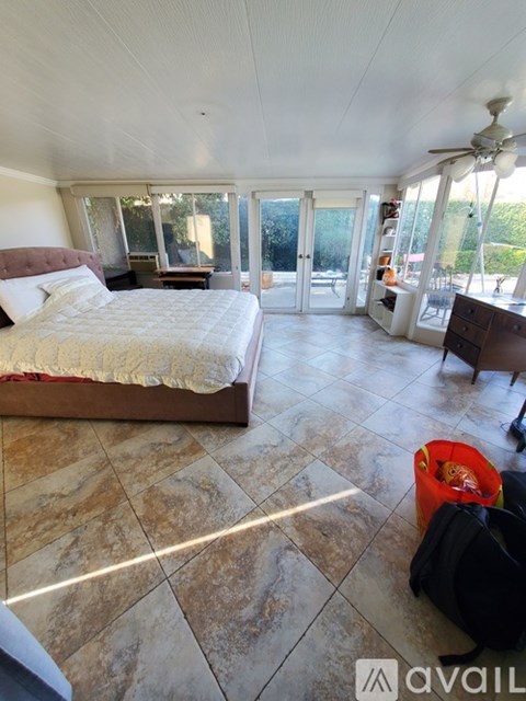 A bedroom with a large bed and a ceiling fan.