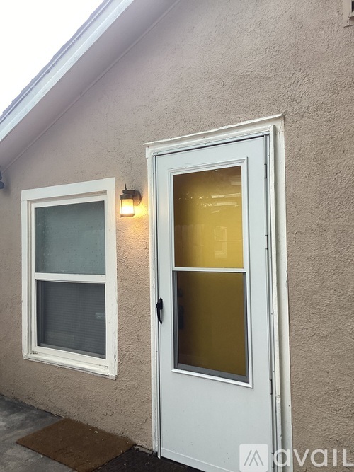 A white door with a glass window is on the right side of a house.