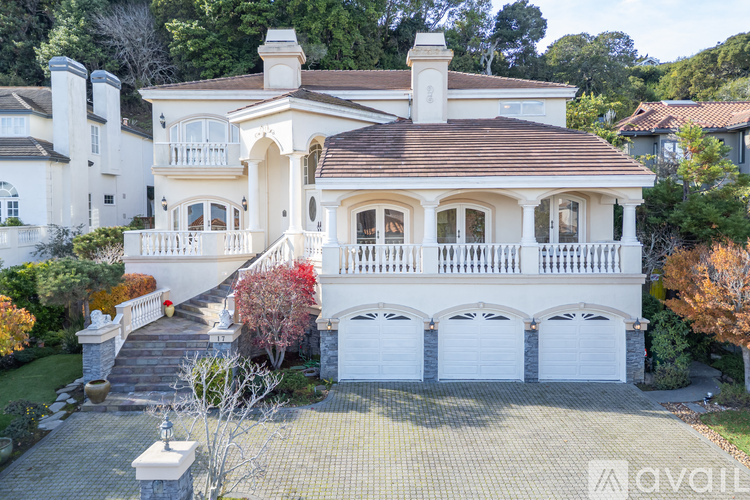 A large white house with a brown roof and a balcony.