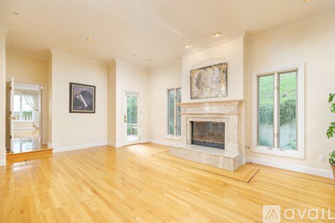 A spacious living room with a fireplace and a painting on the wall.