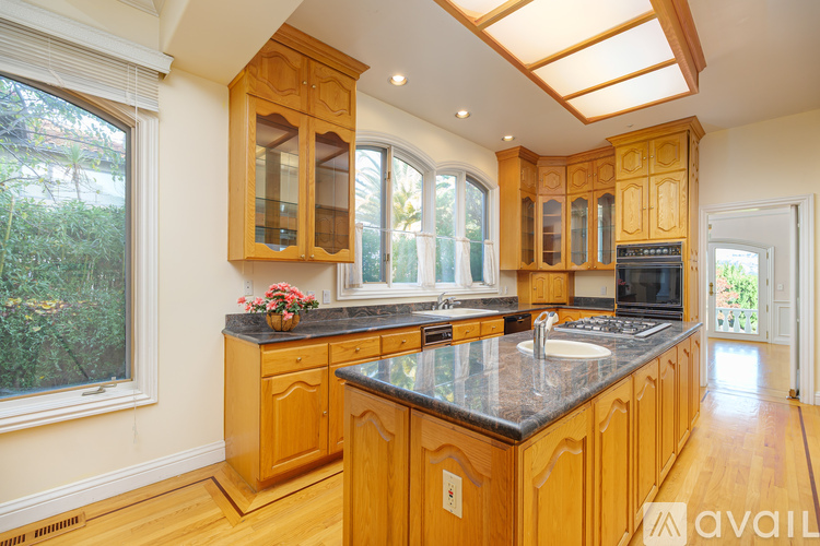 A kitchen with wooden cabinets and a black countertop.