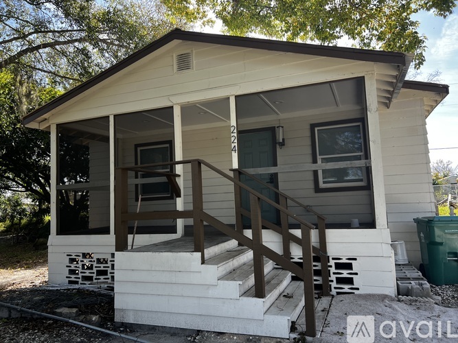 A small house with a porch and stairs leading to the front door.