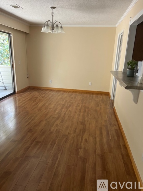 A room with wooden flooring and a light fixture.