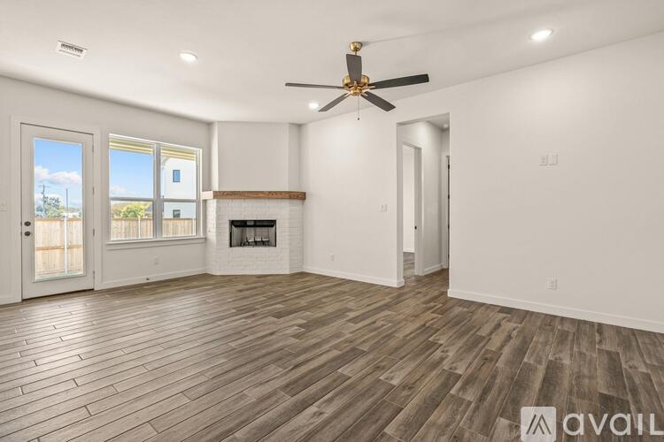 A spacious room with a fireplace and a ceiling fan.
