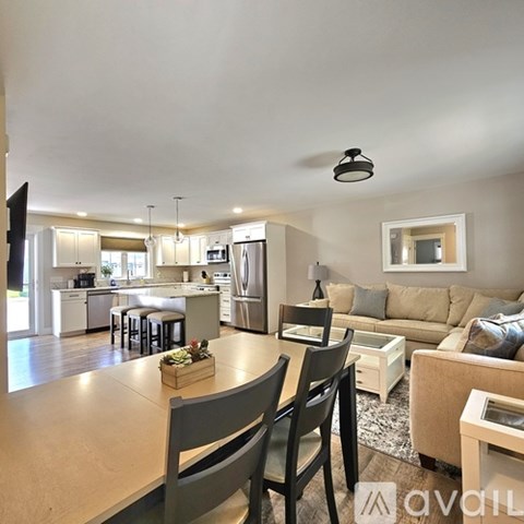 A modern kitchen and dining area with a large island and bar stools.