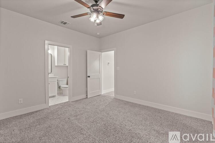 A room with a ceiling fan and carpeted floor.