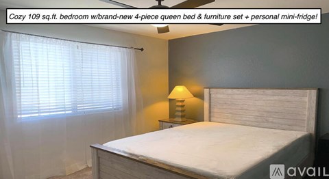 A bedroom with a bed, a lamp, and a fan.