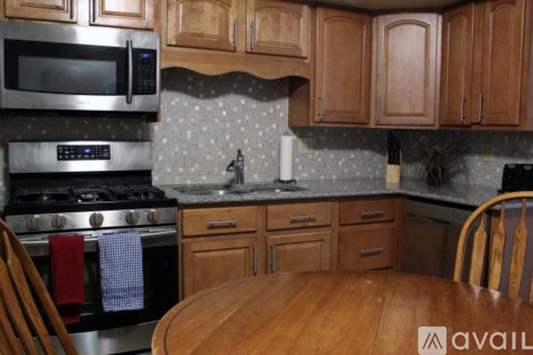 A kitchen with wooden cabinets and a stove top oven.