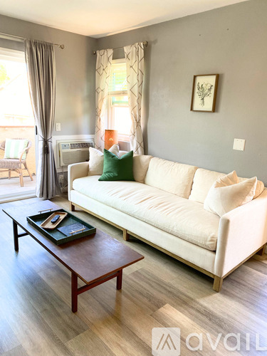 A living room with a white couch and a wooden coffee table.