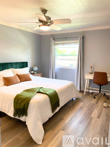 A bedroom with a bed, chair, and window.