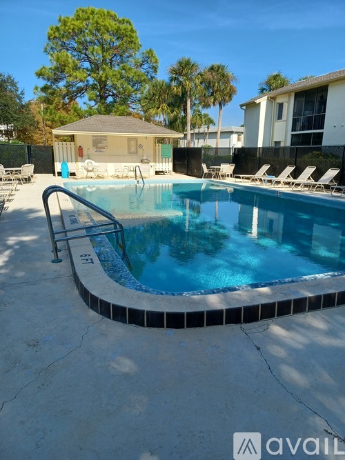 A pool with a blue tiled edge and a metal ladder.