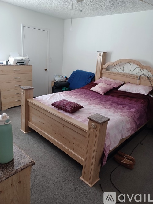 A bedroom with a bed, dresser, and nightstand.