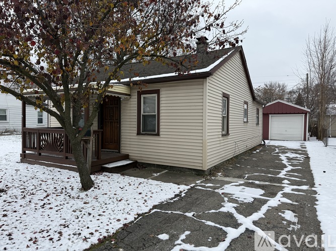 A small house with a brown tree in front of it.