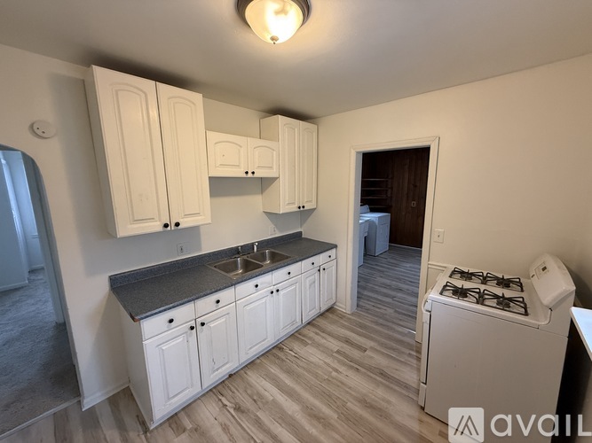 A kitchen with white cabinets and a black stove top oven.