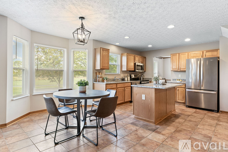 A kitchen with a table and chairs in the middle of the room.