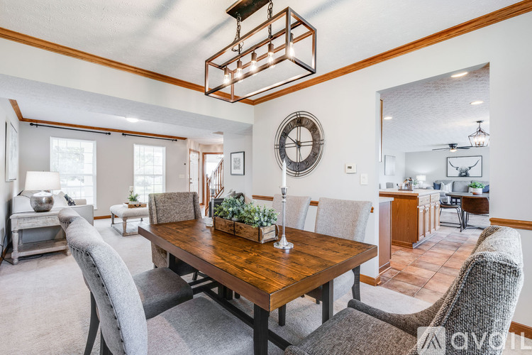 A dining room with a wooden table and grey chairs.