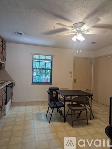 A dining room with a table and chairs.