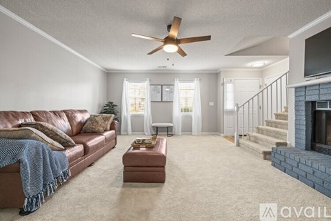 A living room with a brown leather couch and a blue throw blanket.