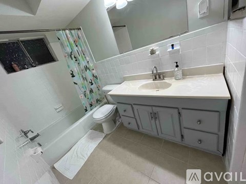 A bathroom with a toilet, sink, and shower.