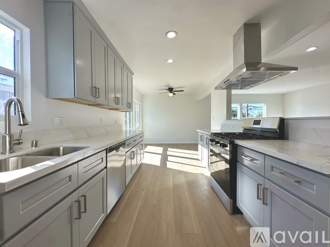 A modern kitchen with stainless steel appliances and wooden floors.