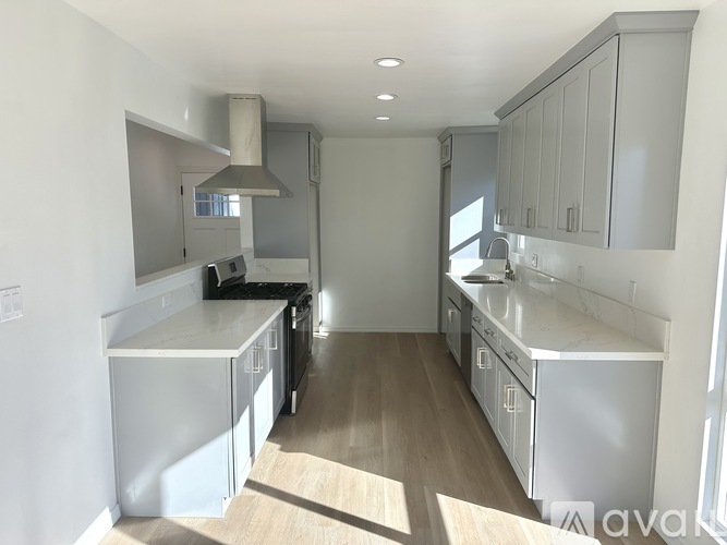 A kitchen with white cabinets and a stainless steel dishwasher.