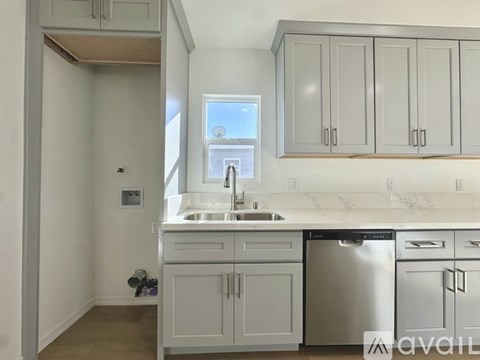 A kitchen with a sink, dishwasher, and cabinets.