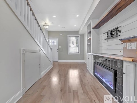 A spacious living room with a fireplace and wooden floors.