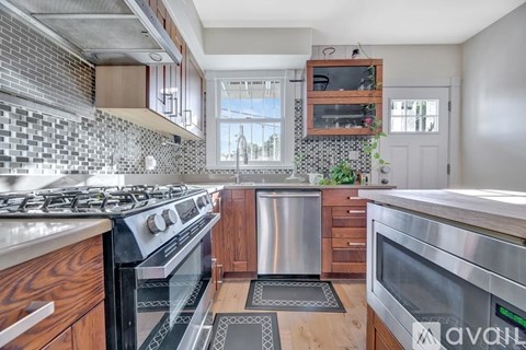 A modern kitchen with a stove top oven and a stainless steel dishwasher.