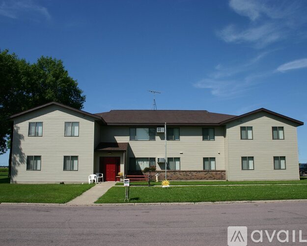 A two-story building with a red door and a brown roof.