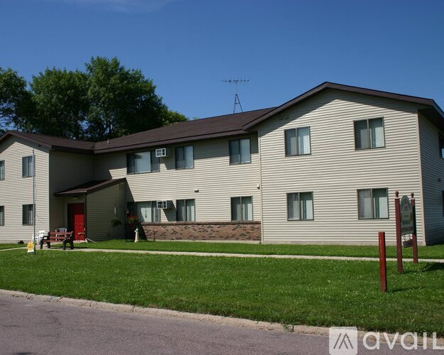 A two-story building with a red door and a brown roof.