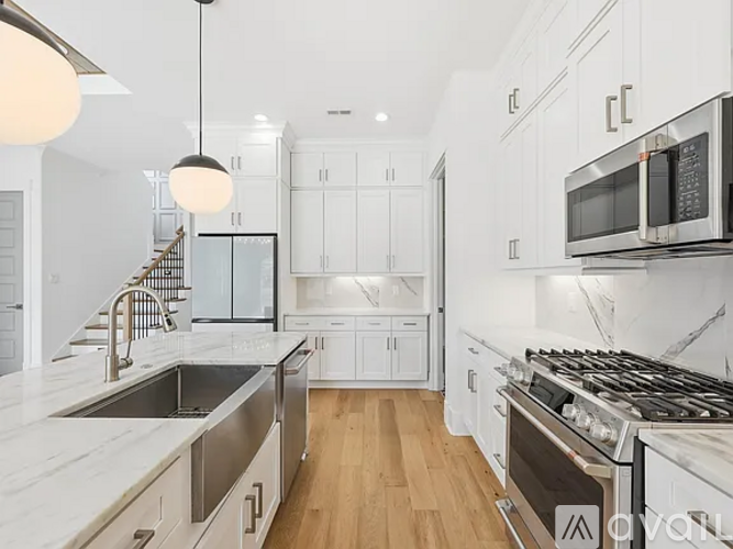 A modern kitchen with white cabinets and a stainless steel stove top.