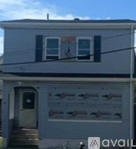 A house with a grey siding and a white door.