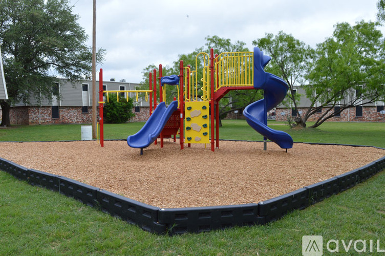 A playground with a blue slide and yellow and red play structures.